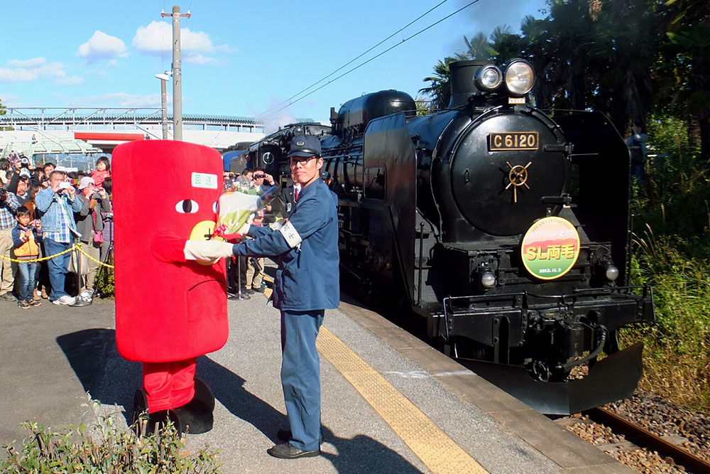 2012.11.03　JR両毛線にSLが走った日、岩宿駅の式典でSLの運転士に花束を渡すわっしー。